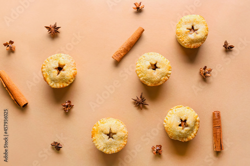 Composition with Christmas mince pies and spices on color background
