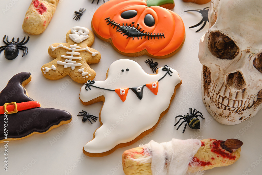 Tasty cookies for Halloween celebration on light background