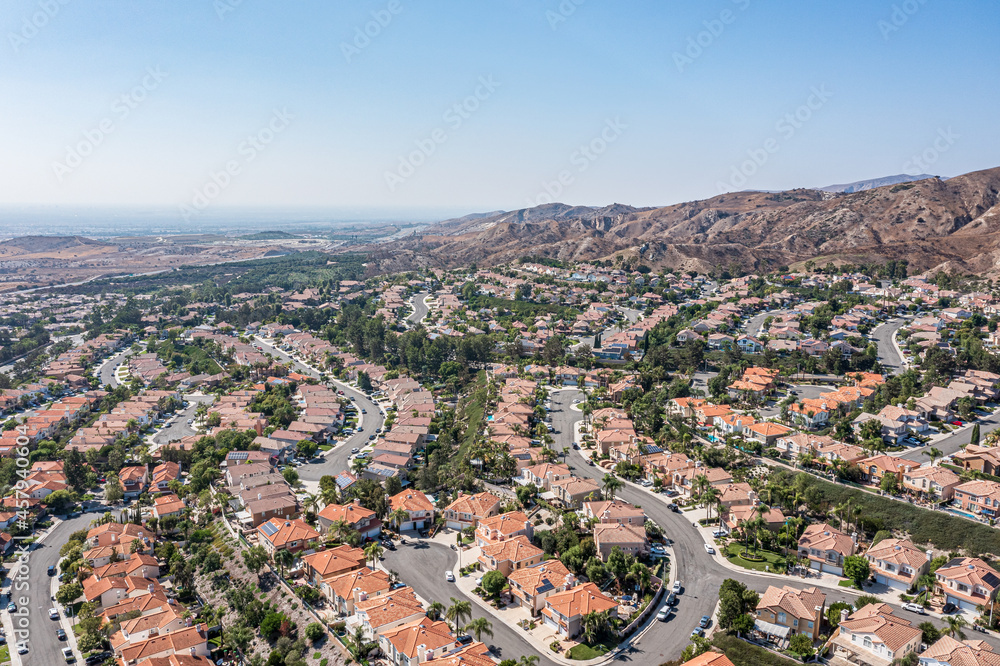 Overhead view of a modern coastal community, ocean, homes and hills on a clear day
