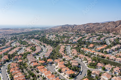Overhead view of a modern coastal community, ocean, homes and hills on a clear day