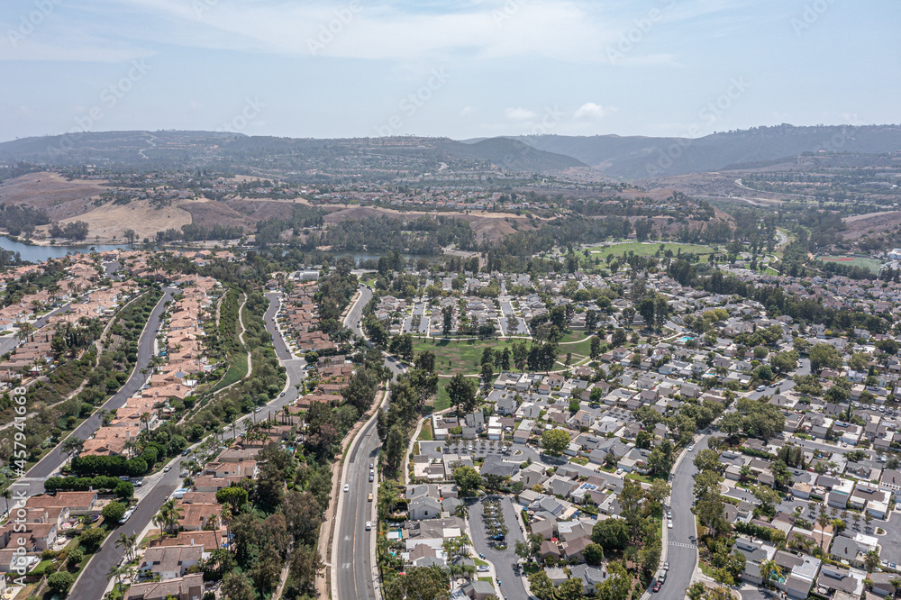 Aerial view of a southern California coastal community on a hill with a community lake in the background