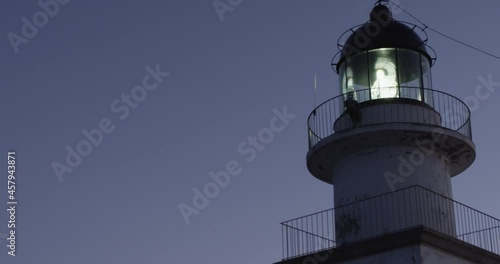The lighthouse Sarnella, rotating signal lights during the evening, Port de la Selva, Costa Brava, Catalonia, Spain