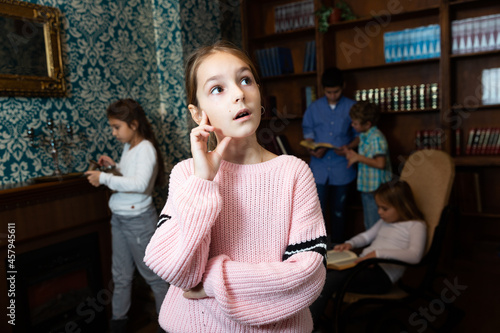 Photos Emotional girl in quest room with friends, trying to find solution of conundrum