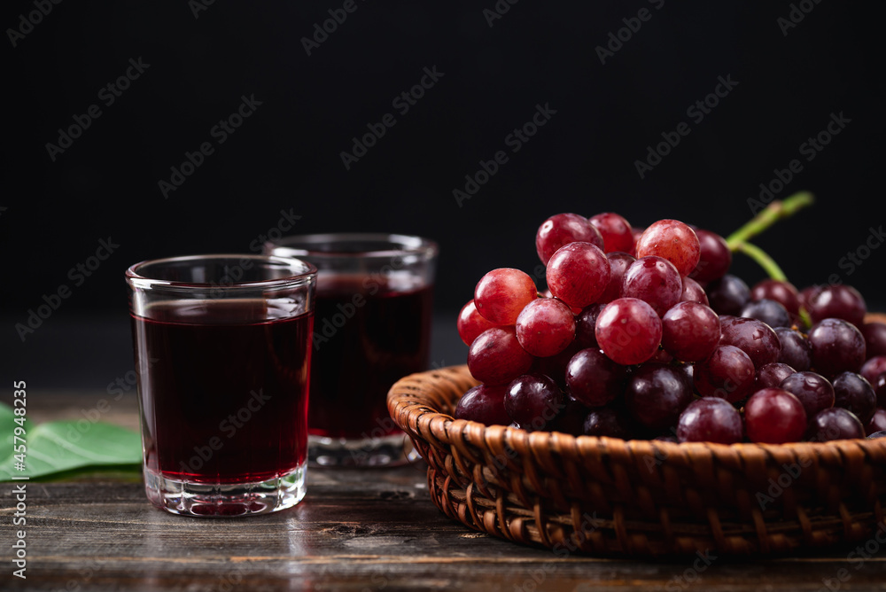 Red grape juice in a glass with fresh grape in a basket on wooden background, Healthy drink, Still Life Red grape juice in a glass with fresh grape in a basket on wooden background, Healthy drink, Still Life