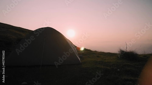 Camping tent at sunset or sunrise. Adventure and camp concept. Sun flare photo