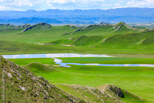 Bayinbuluke grassland natural scenery in Xinjiang,China.The winding river is on the green grassland.