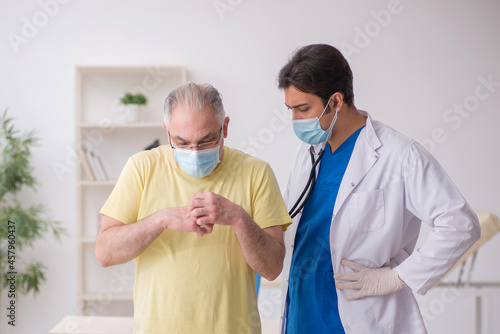 Old male patient visting young male doctor photo