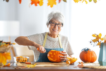 woman is carving pumpkin