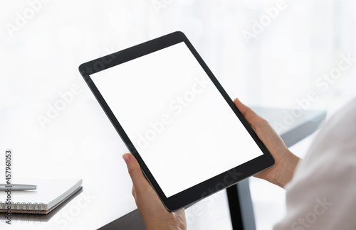 Close up of hand holding tablet with white mock-up screen.
