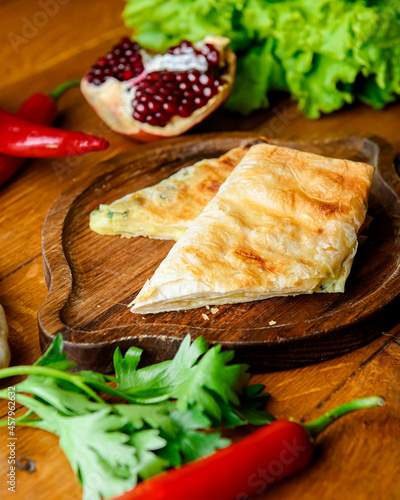 Homemade lavash bread with vegetables, spinach and lettuce on old wooden background.