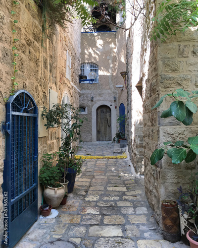 Scenic street alley view of historic houses and buildings in Old Town downtown Yaffa Jaffa  Israel near Tel Aviv with romantic backstreets  parks and medieval facades and skyline