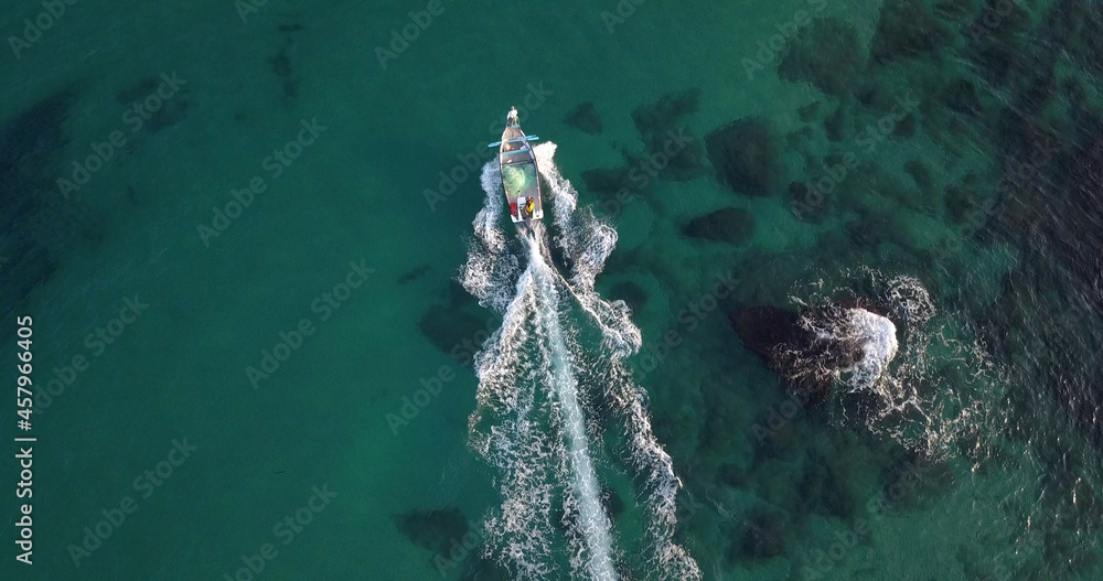 Small fishing boat sails off the coast of Tel Aviv, aerial
Drone view from Tel aviv Jafa at sunrise, 2021

 - obrazy, fototapety, plakaty 