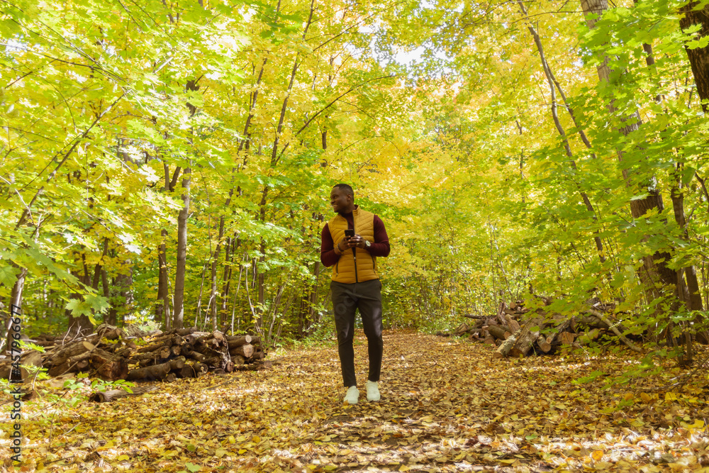 African american student walking in the park in autumn season African american student walking in the park in autumn season