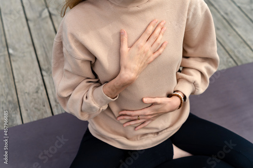 Close-up of a woman's hands on her chest while doing breathing exercises photo