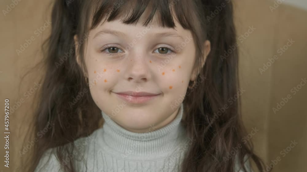 Making Jack for Halloween. A child with orange drawn freckles hold a pumpkin in her hands. Making Jack for Halloween. A child with orange drawn freckles hold a pumpkin in her hands.