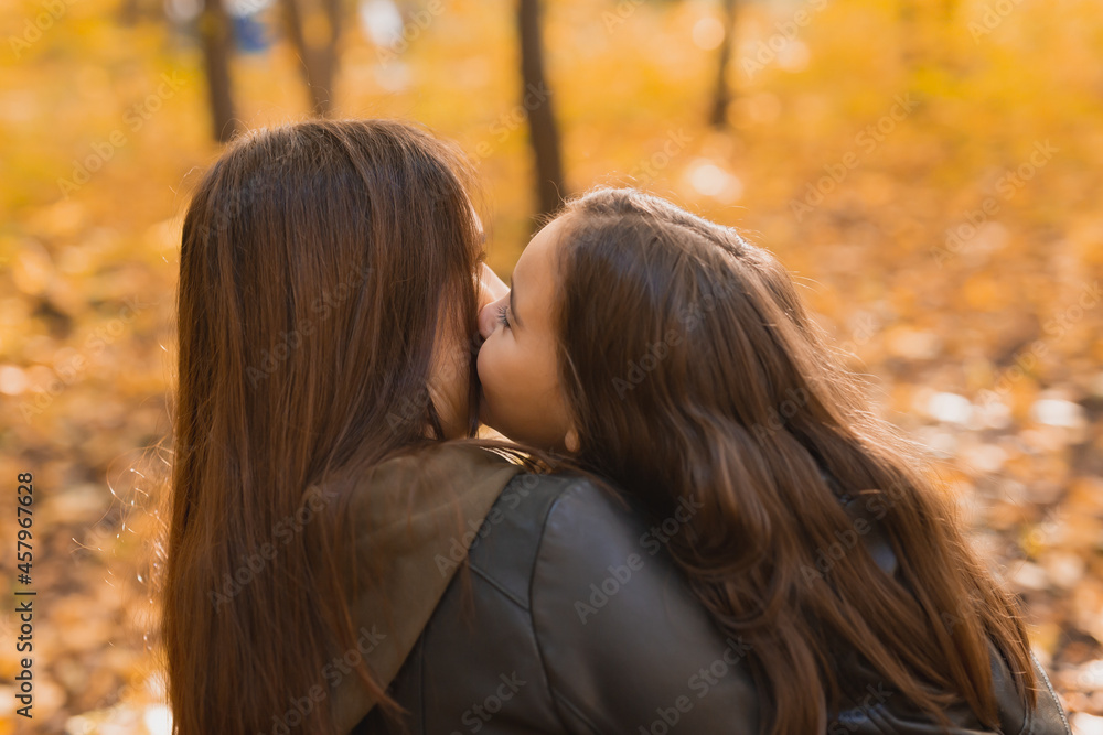Fototapeta premium Mother and daughter spend time together in autumn yellow park. Season and single parent concept.