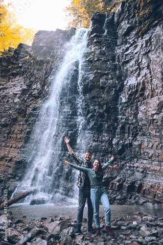 couple in front of waterfall autumn season