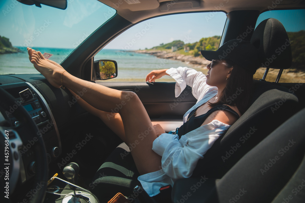 woman sitting in car show sexy legs looking at summer sea beach