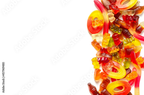 A pile of assorted of chewy jelly fruit candies on a white background. Copy space. Holiday concept, children delighted, unhealthy nutrition.