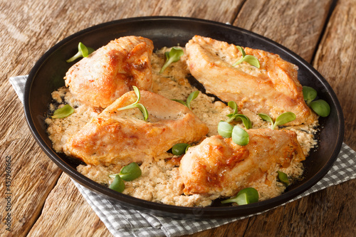 Amish chicken pieces baked in the flour and spices closeup in the plate on the table. Horizontal