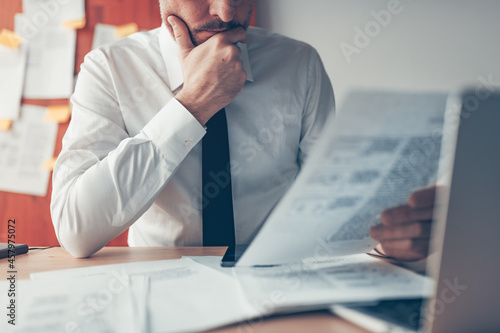 Canvas-taulu Businessman reading business report document at office desk