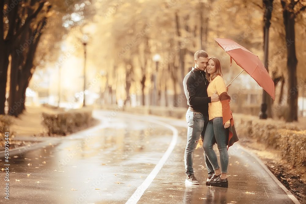 two people under an umbrella / a man and a woman are walking in a park with an umbrella, walking in the fall in the rain, an autumn umbrella two people under an umbrella / a man and a woman are walking in a park with an umbrella, walking in the fall in the rain, an autumn umbrella