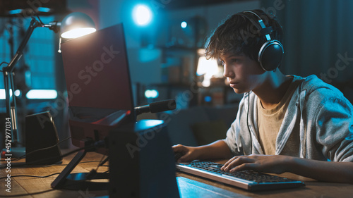 Photo Teenager wearing headphones and playing online video games