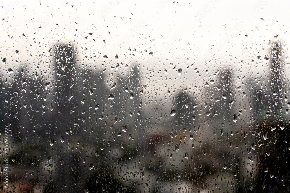 Obraz premium Rain droplets on a window with the Bangkok city skyline in the background