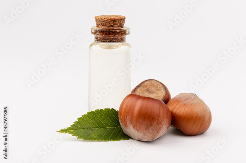 Hazelnut oil in glass bottle isolated on white background. Hazelnut background, healty food