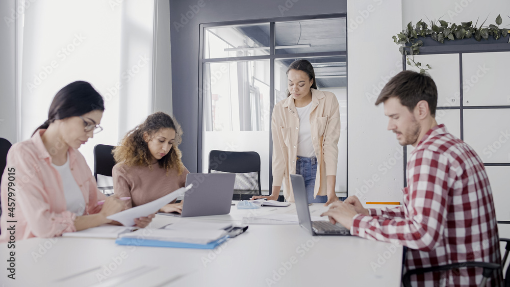 PR specialist talking to colleagues during meeting, teamwork in office, business PR specialist talking to colleagues during meeting, teamwork in office, business