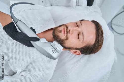 Φωτογραφία Cute bearded patient undergoing the ultrasonic skin tightening