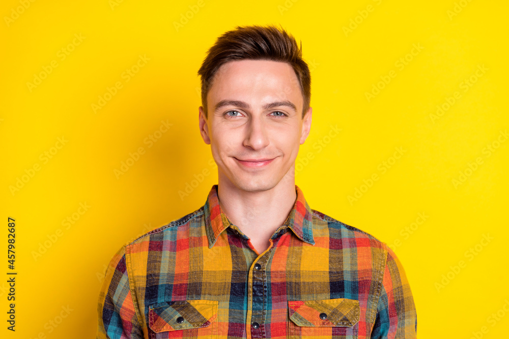Portrait of attractive cheerful content brown-haired guy worker wearing checked shirt isolated over bright yellow color background Portrait of attractive cheerful content brown-haired guy worker wearing checked shirt isolated over bright yellow color background