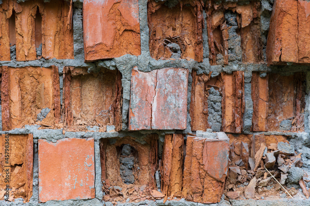 Fragment of a brick wall collapsing from external factors closeup Fragment of a brick wall collapsing from external factors closeup