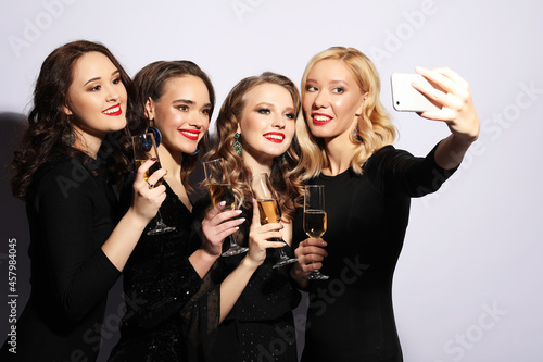 Close-up shot of group of laughing girls having party, take selfie with smartphone.