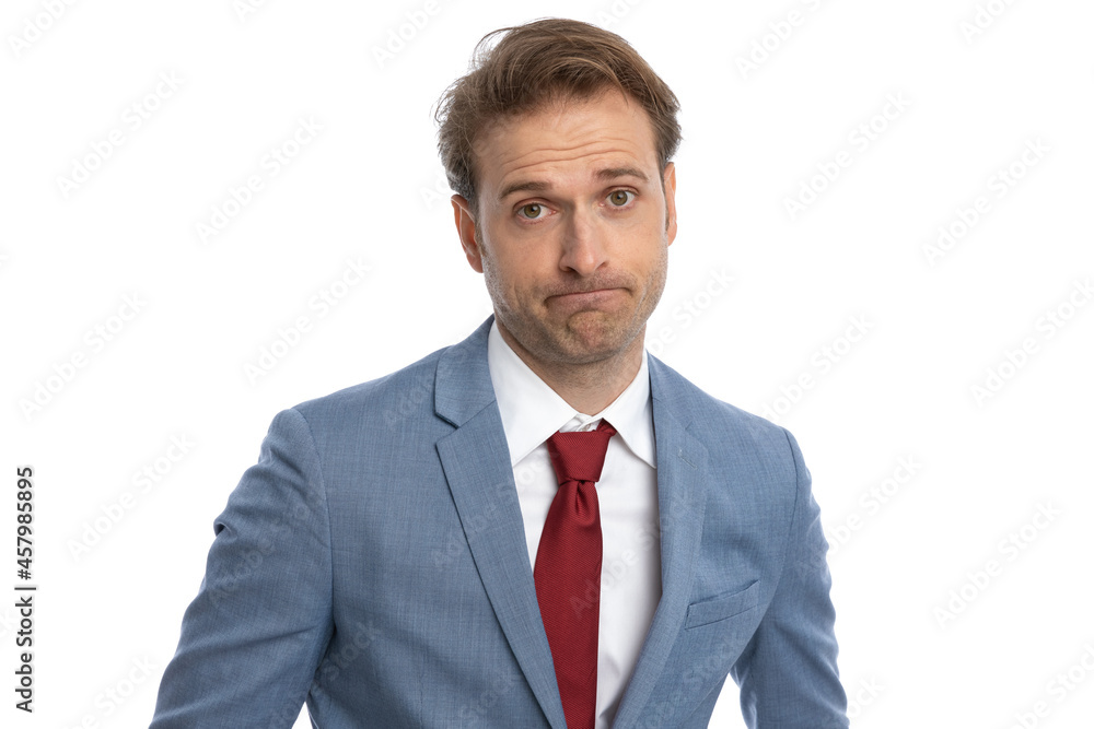elegant young guy in blue suit making a disappointed face and posing elegant young guy in blue suit making a disappointed face and posing