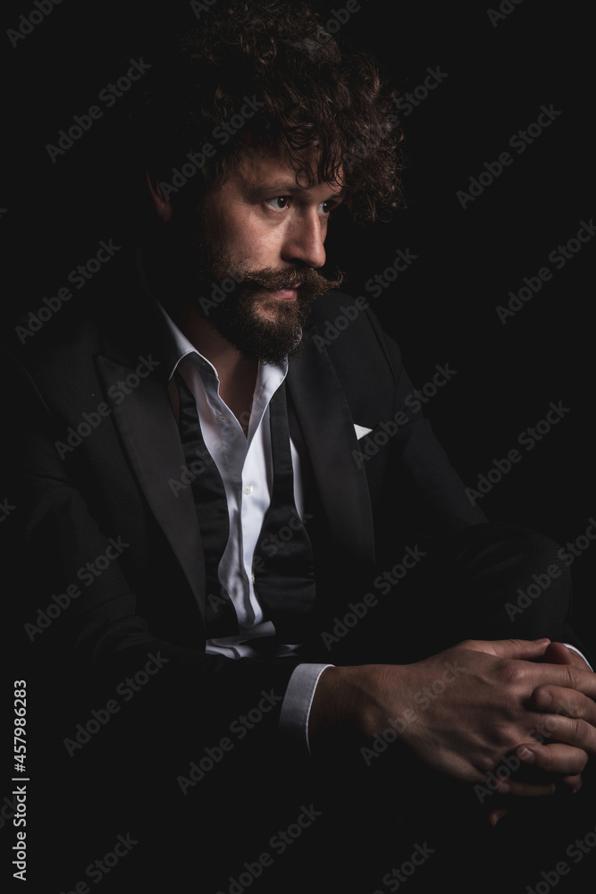 handsome businessman holding his leg and looking away handsome businessman holding his leg and looking away