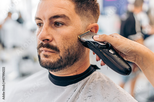 Portrait of a man being shaved in a barbershop