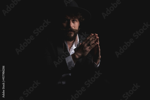 seated fashion model holding his hands together