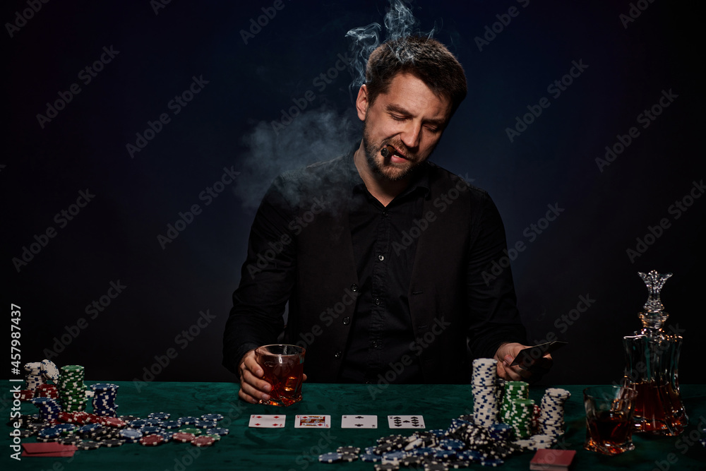 Bearded casino player man playing poker on green table Bearded casino player man playing poker on green table
