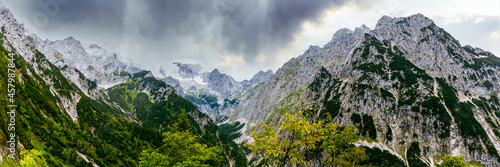 View to the Impressive gorge, Höllentalklamm, Hell Valley Gorge near Grainau with dramatic rain and cloud sky and sunshine. Höllental, Germany, Europe. Canyon near Zugspitze Mountain in Bavaria