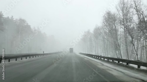 View through the windshield of a car on the autobahn in winter in heavy snow.