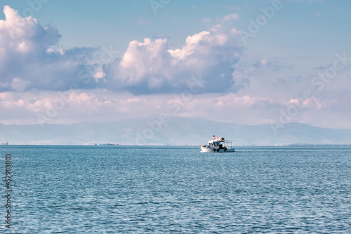 Seascape with clouds, ocean and a trawler fishing boat