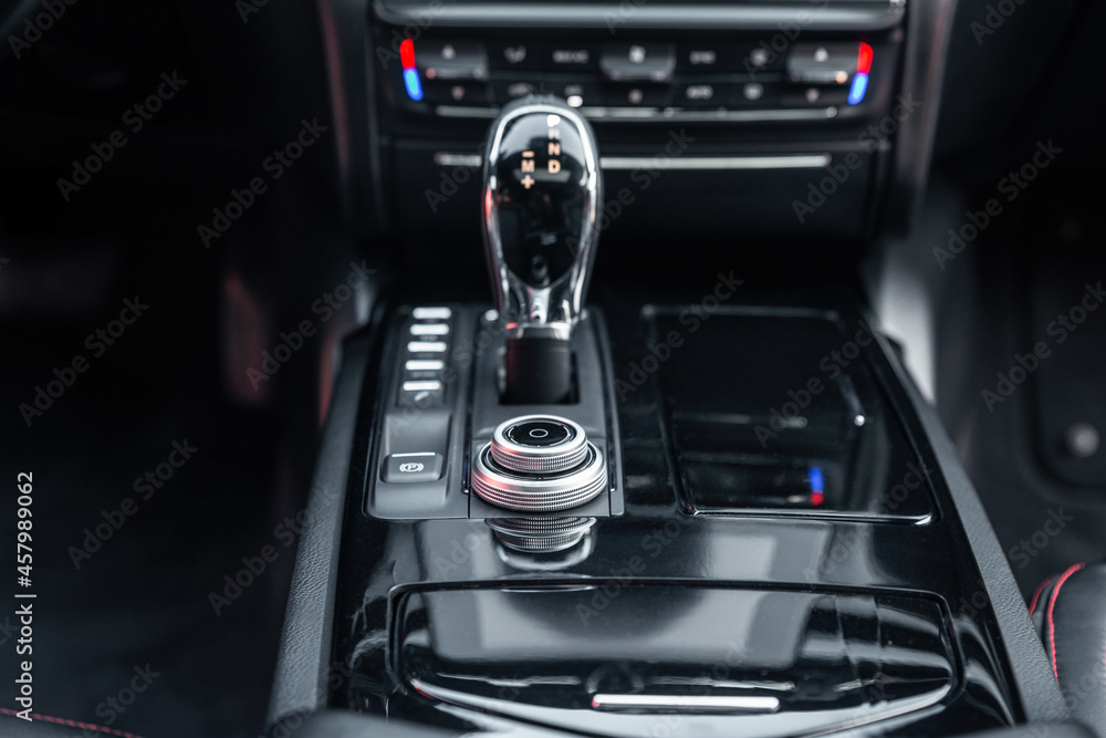 Naklejka premium Modern luxury car interior. Control panel, radio system, shift lever. Automatic transmission gearshift stick. Selective focus.