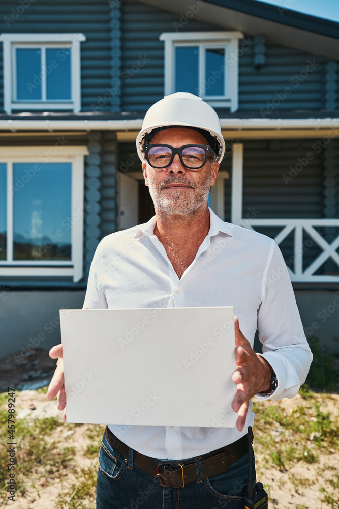 Confident engineer holding blank piece of paper Confident engineer holding blank piece of paper