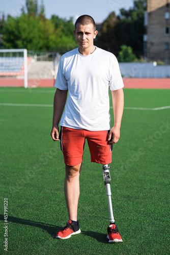 Portrait of young caucasian male athlete brunette with prosthetic leg on the stadium on the field