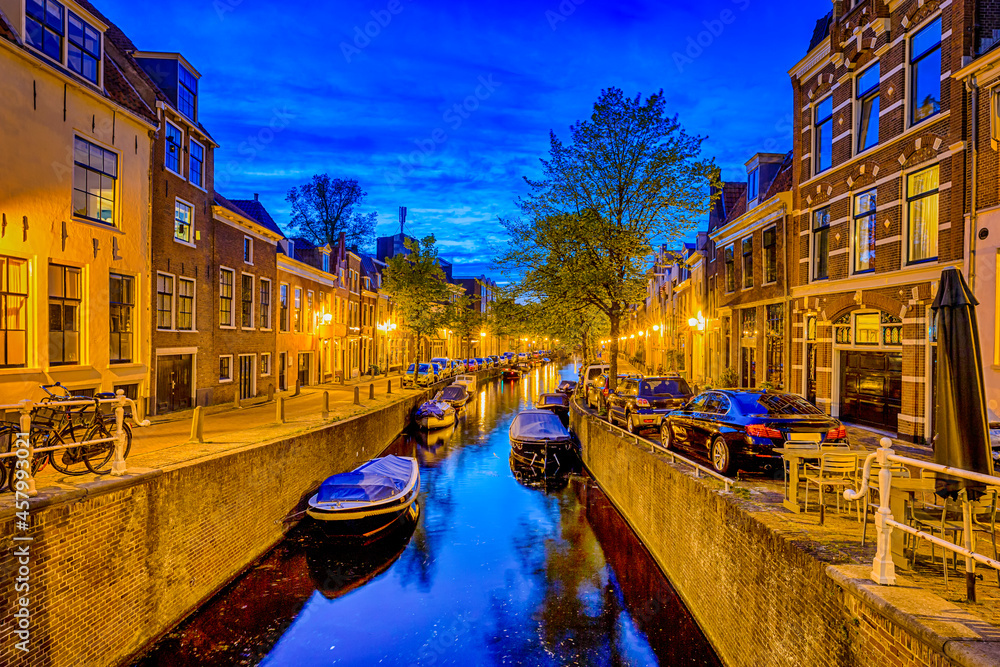 Romantic Travel in The Netherlands. Water Channels in The City of Amsterdam in The Netherlands at Twlight with Boats Across Banks