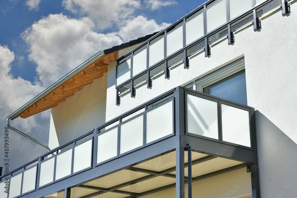 Moderner Balkon mit Sichtschutz aus Mattglasplatten und Metall-Geländer an einer Neubau-Hausfront Moderner Balkon mit Sichtschutz aus Mattglasplatten und Metall-Geländer an einer Neubau-Hausfront