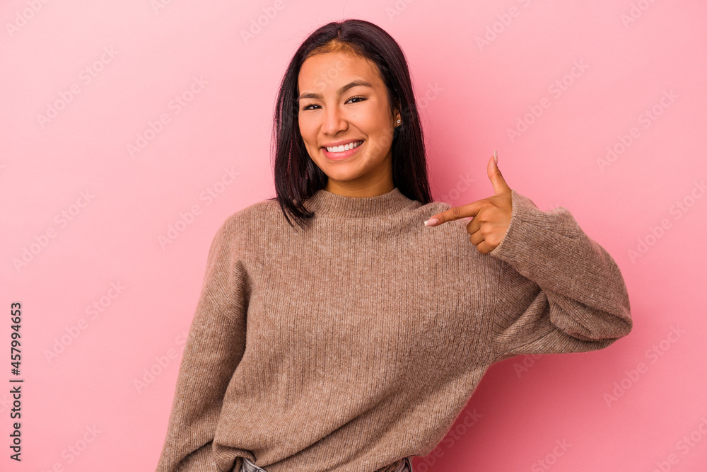 Young latin woman isolated on pink background person pointing by hand to a shirt copy space, proud and confident Young latin woman isolated on pink background person pointing by hand to a shirt copy space, proud and confident