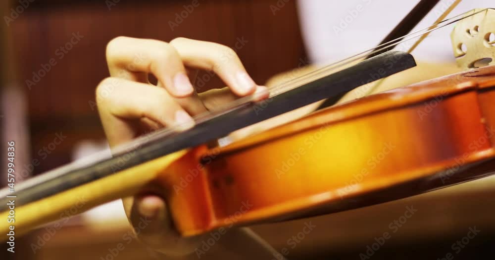 blurry hand of a young violinist presses the strings on the violin neck, blurry hand of a young violinist presses the strings on the violin neck,