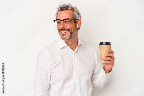 Middle age business man holding a take away coffee isolated on white background looks aside smiling, cheerful and pleasant.